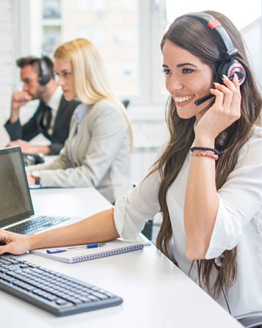 Friendly smiling woman call center operator with headset using c